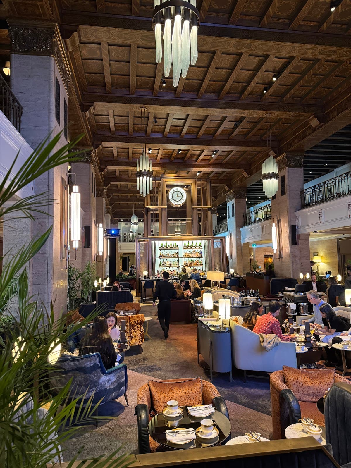 Elegant interior with high ceilings, leather seating, and a bar in the background in Toronto
