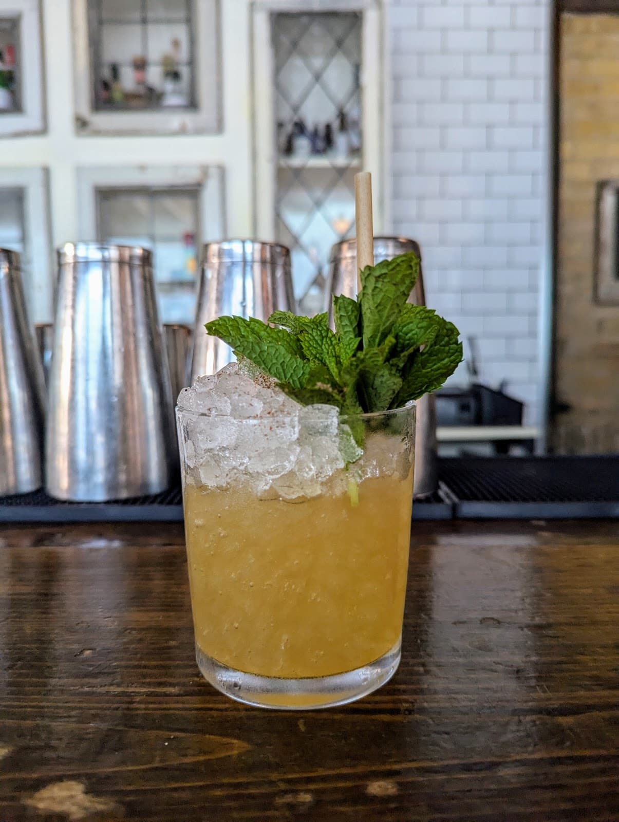 Cocktail with crushed ice and mint garnish on a bar counter in Toronto