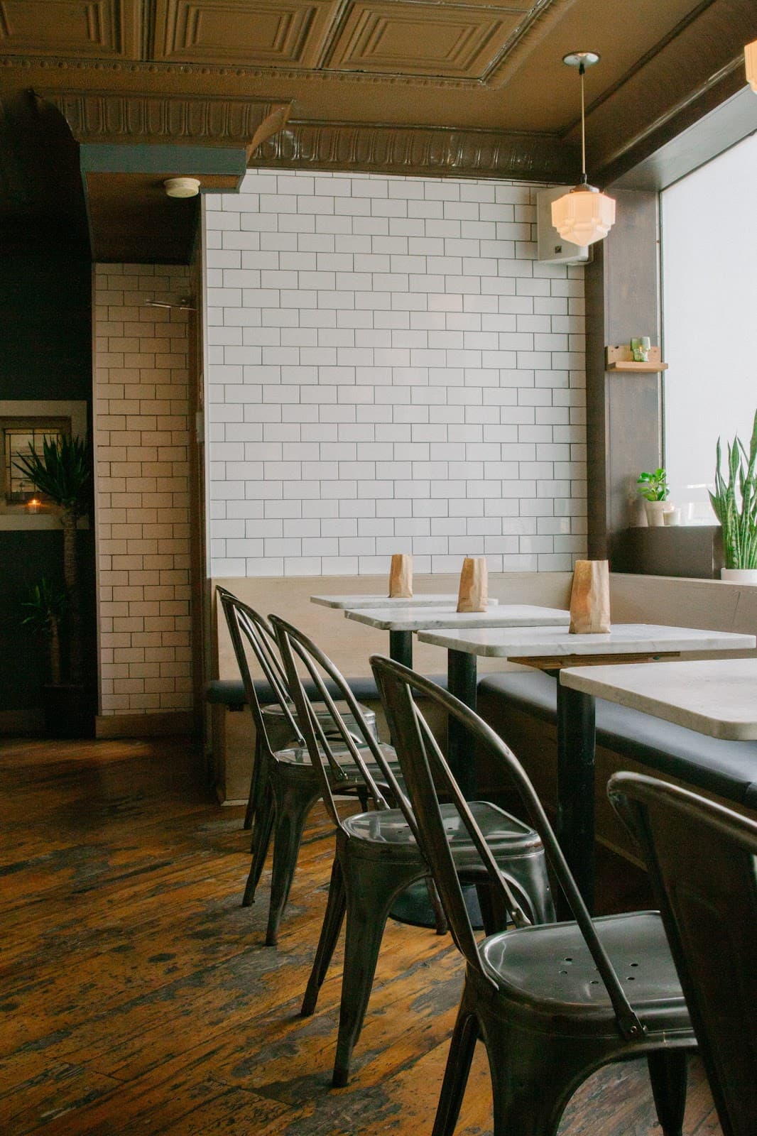Interior seating area with metal chairs and white tile walls in Toronto