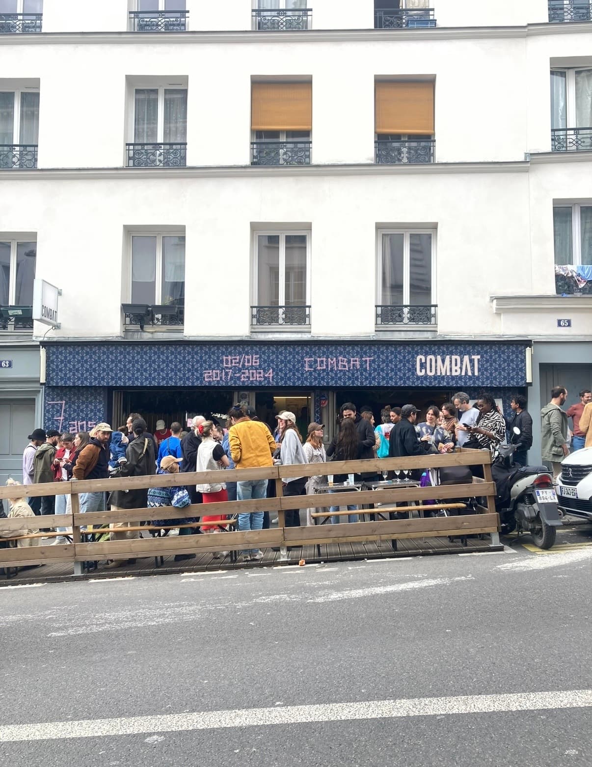 Exterior of Combat bar with people gathered outside in Paris