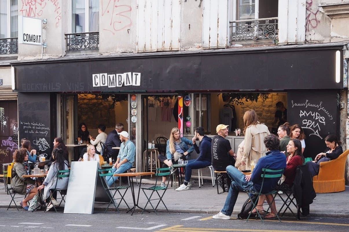Outdoor seating at Combat cocktail bar with people enjoying drinks in Paris