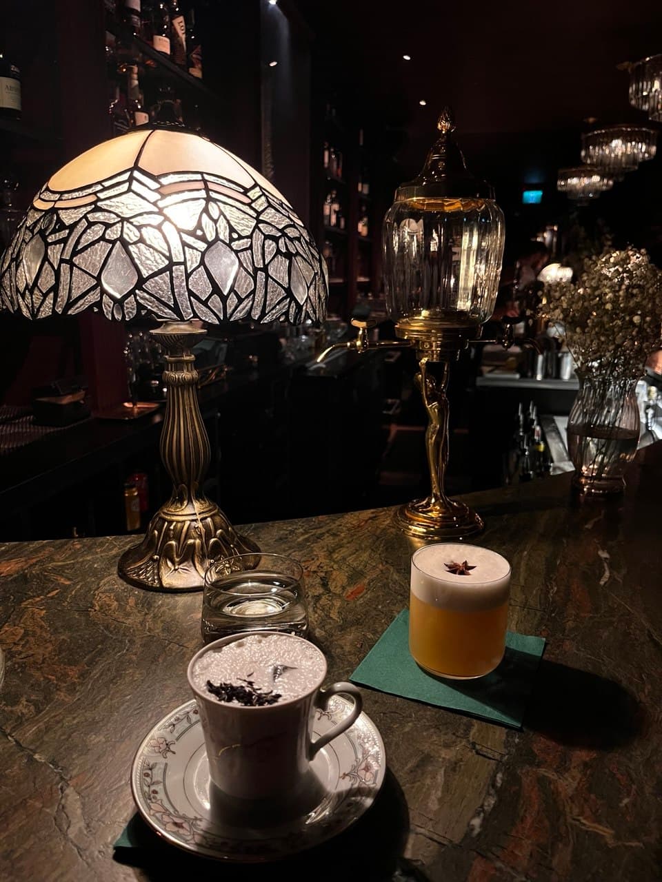 Close-up of a bar counter with drinks, vintage lamps, and decorative elements. in Toronto