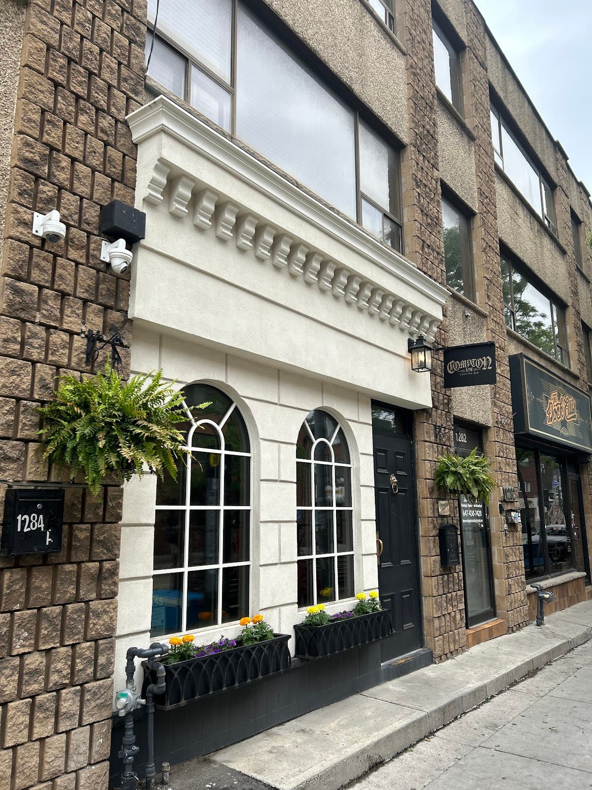 Exterior of a building with arched windows and flower boxes at its entrance in Toronto
