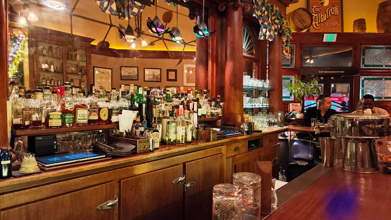 Warm-lit bar with wooden counters and a variety of bottles at The Albatross Saloon in San Francisco