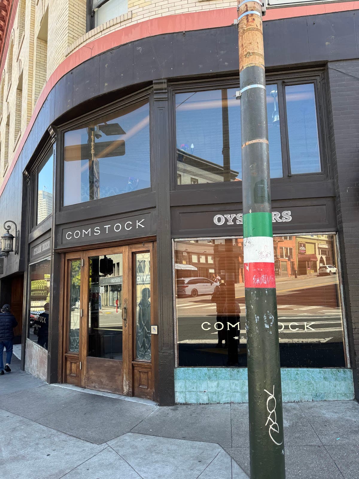 Exterior of Comstock bar with large windows and entrance in San Francisco