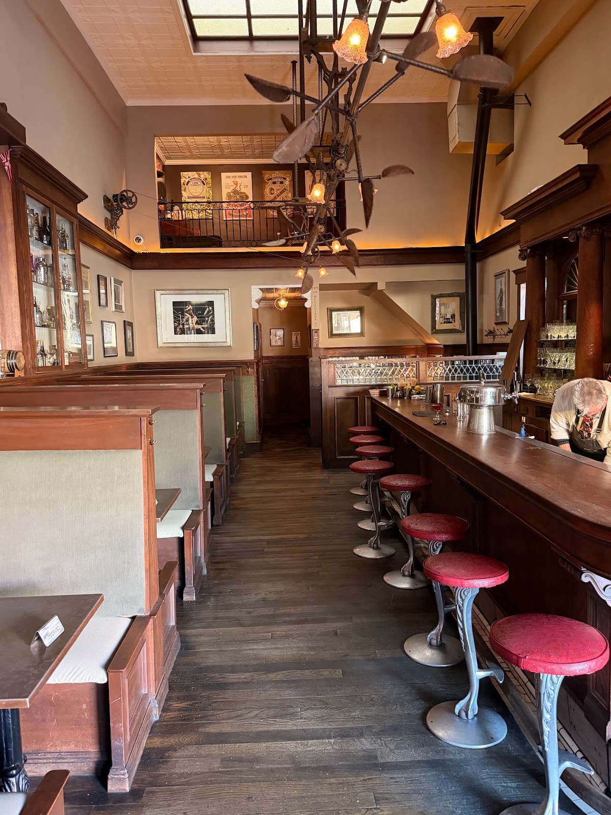Interior of a cocktail bar with red stools and a wooden bar counter in San Francisco