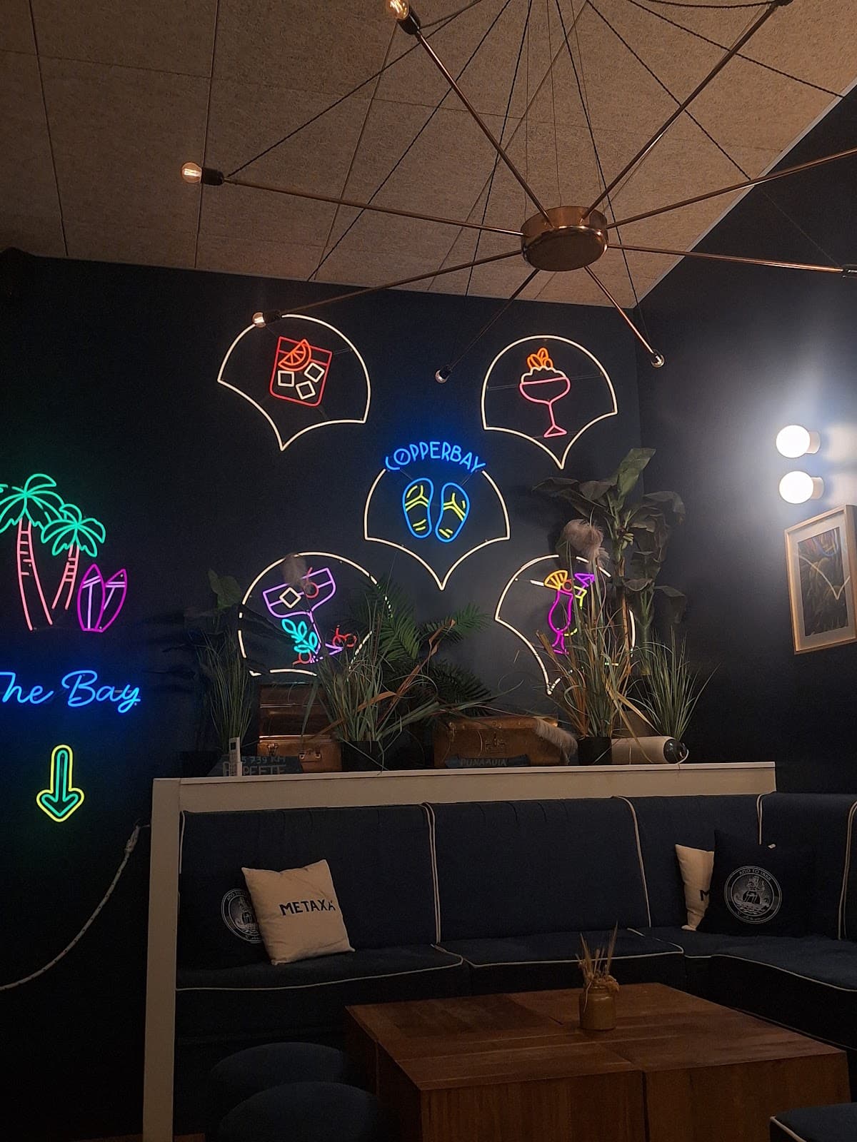 Cozy bar interior with neon signs and dark seating at CopperBay in Paris