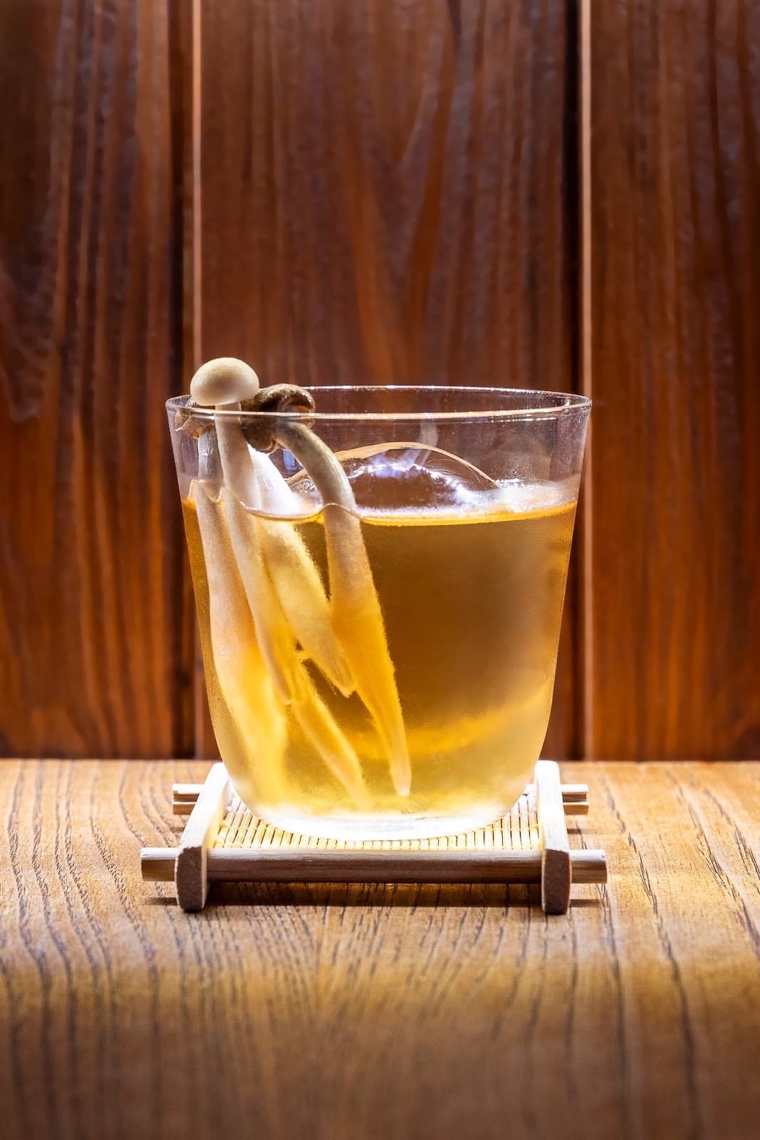 Artistic cocktail with a wooden backdrop and mushroom garnish on the glass in Lisboa