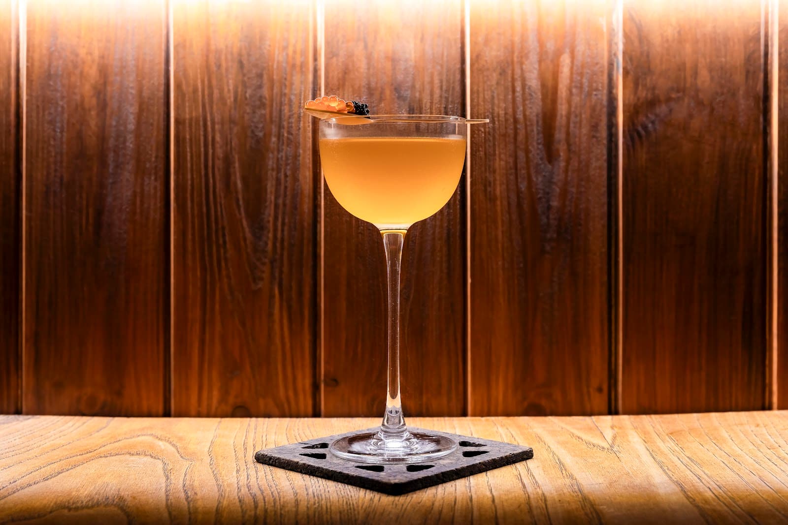 Elegant cocktail on wooden bar with warm lighting in Lisboa