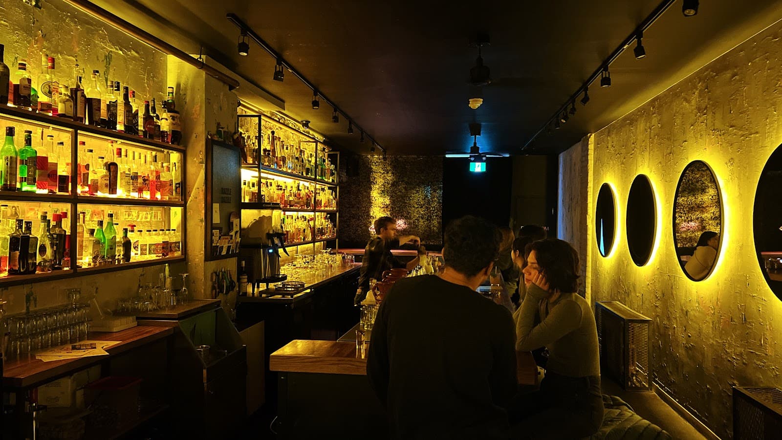Stylish bar interior with illuminated bottle shelves and moody lighting
