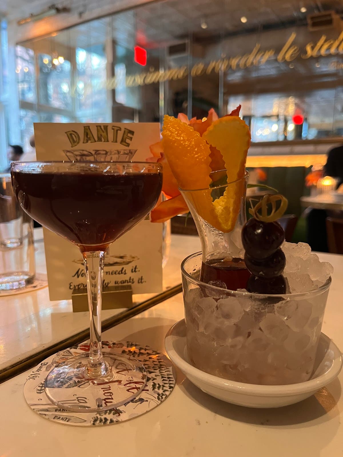 Cocktail with orange garnish on a bar counter at Dante in New York