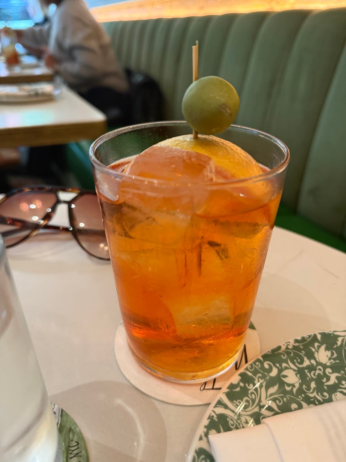 Close-up of cocktail with an olive garnish on a table in New York