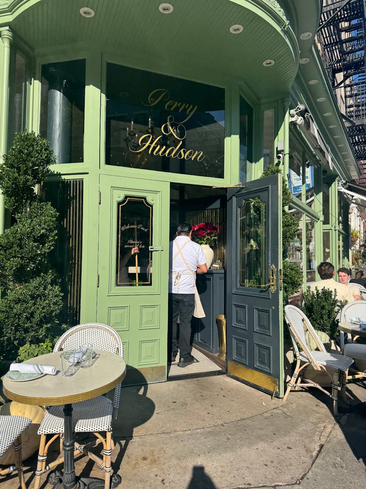 Exterior of Perry & Hudson with open doors and outdoor seating. in New York
