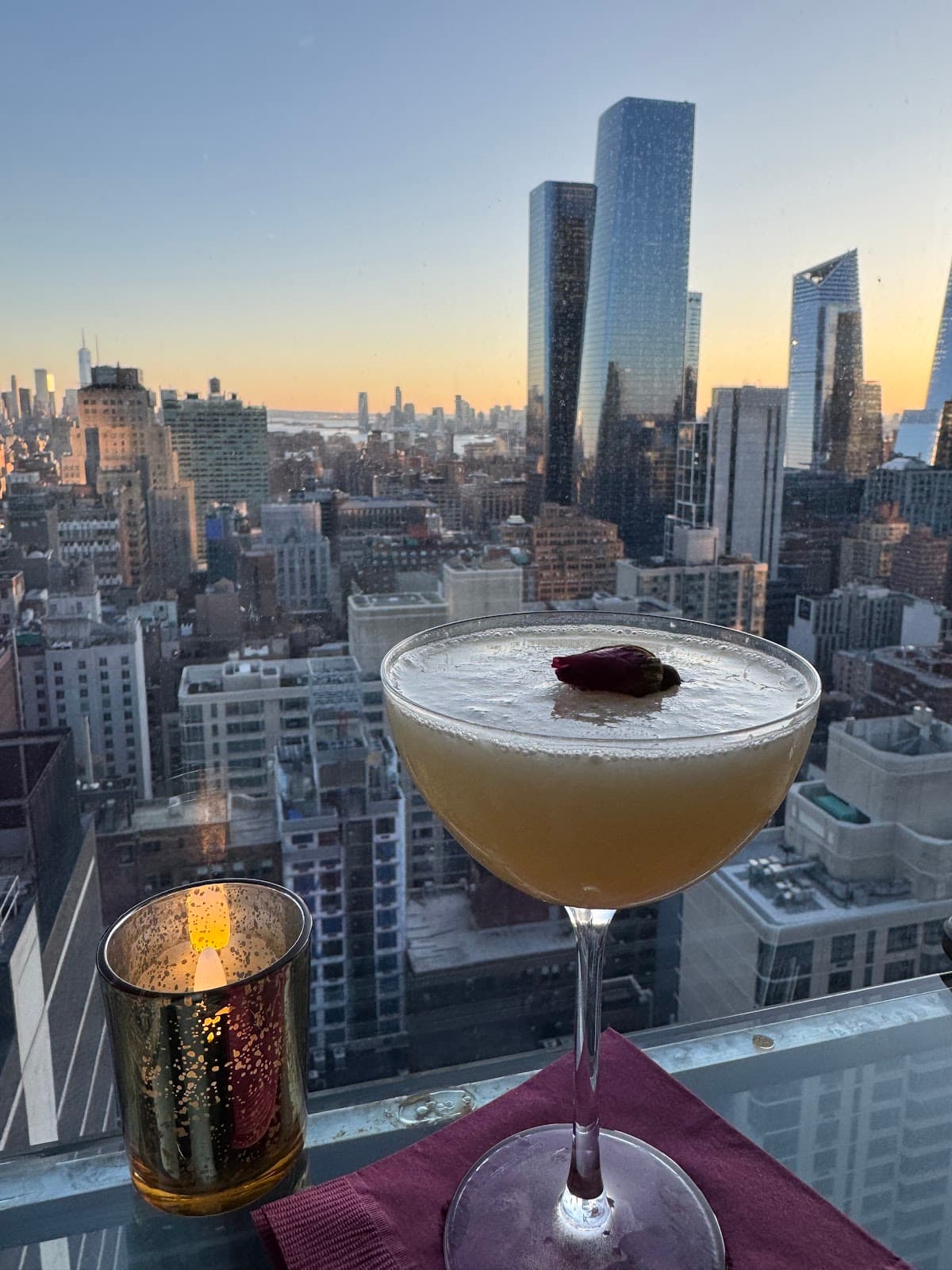 Cocktail on a city rooftop with skyline view at sunset in New York