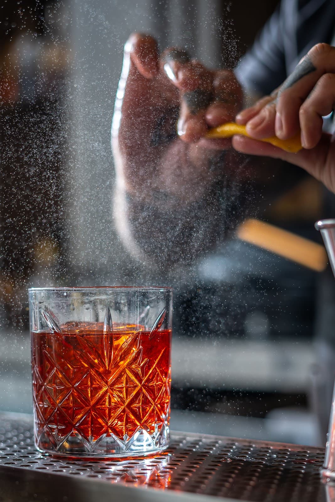 Bartender adding zest to a crafted cocktail in a crystal glass in New York