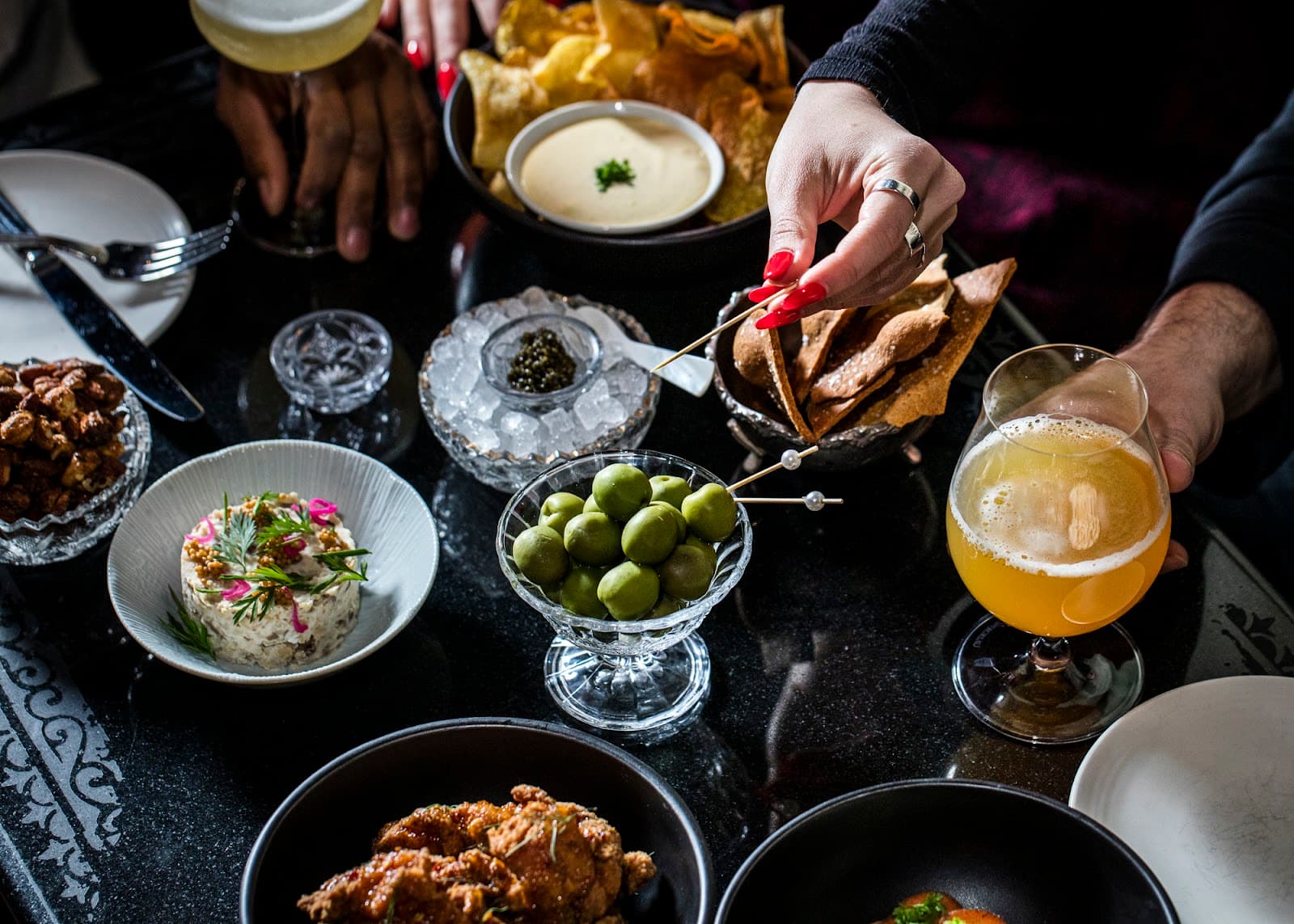 Table with assorted appetizers and a cocktail glass in a bar setting in New York