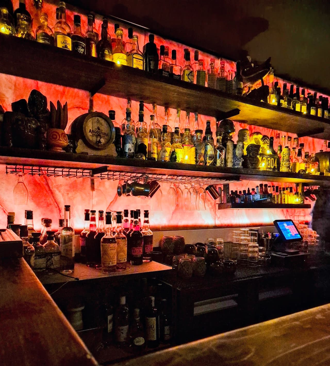 Backlit bar shelves with bottles and moody lighting in Paris