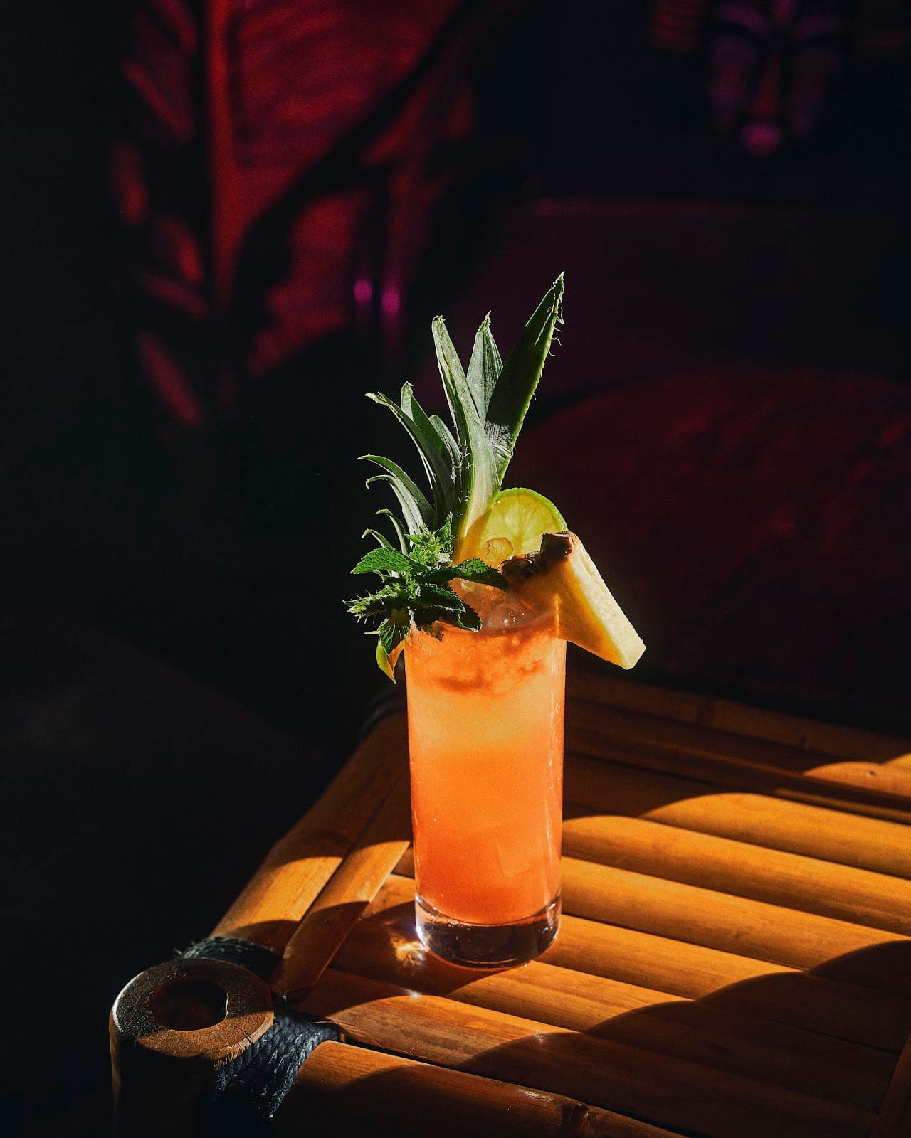 Tropical cocktail with pineapple garnish on a wooden table in Paris