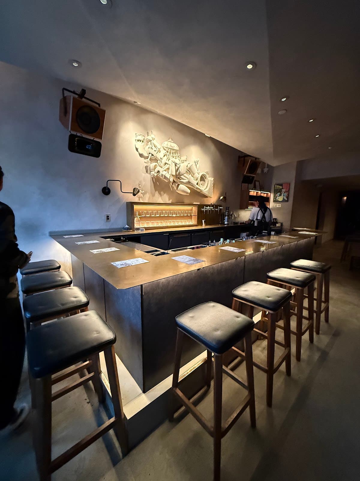 Contemporary bar with high stools and artistic wall decor in New York