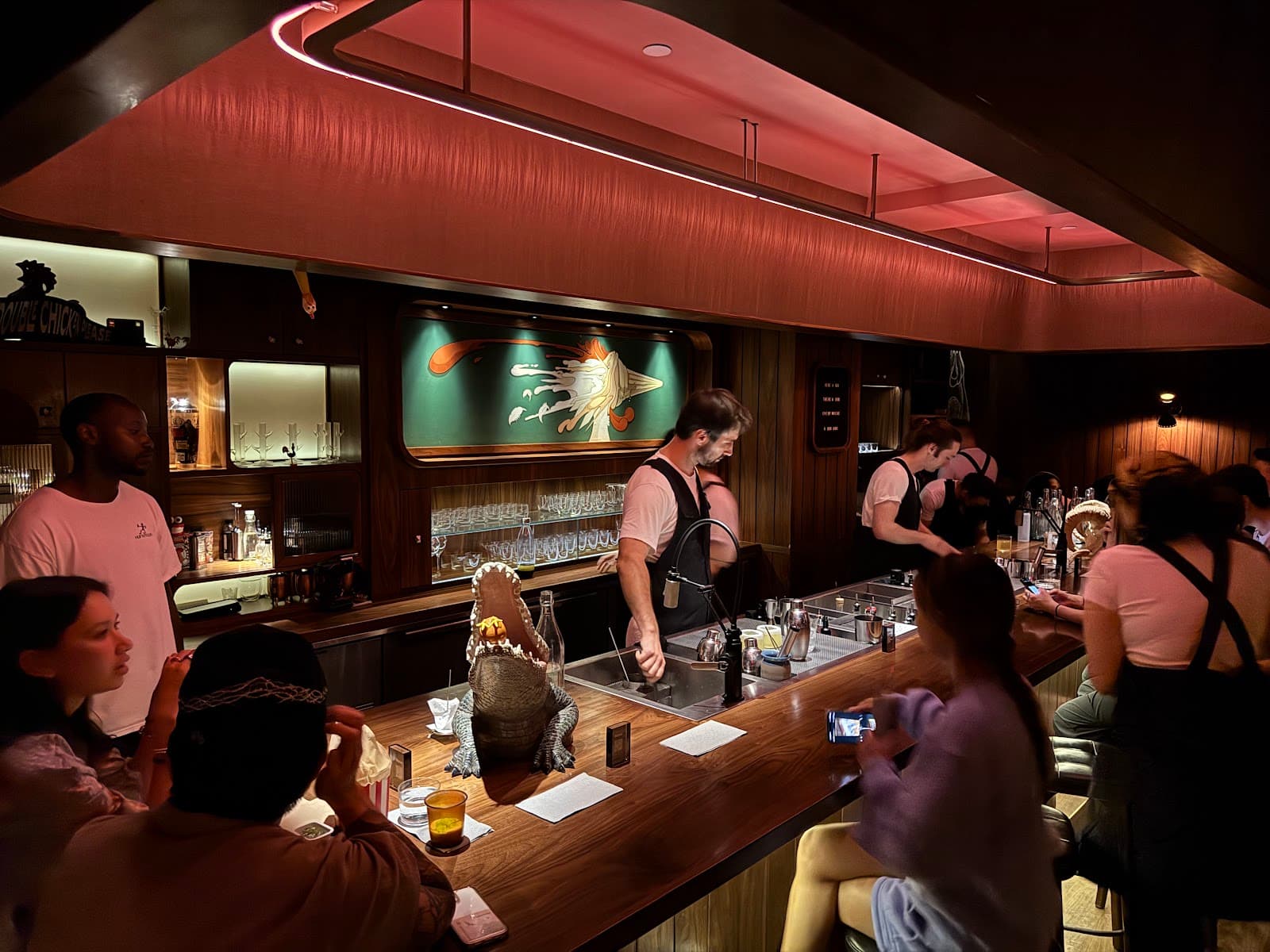 Stylish bar with bartenders serving drinks under warm lighting