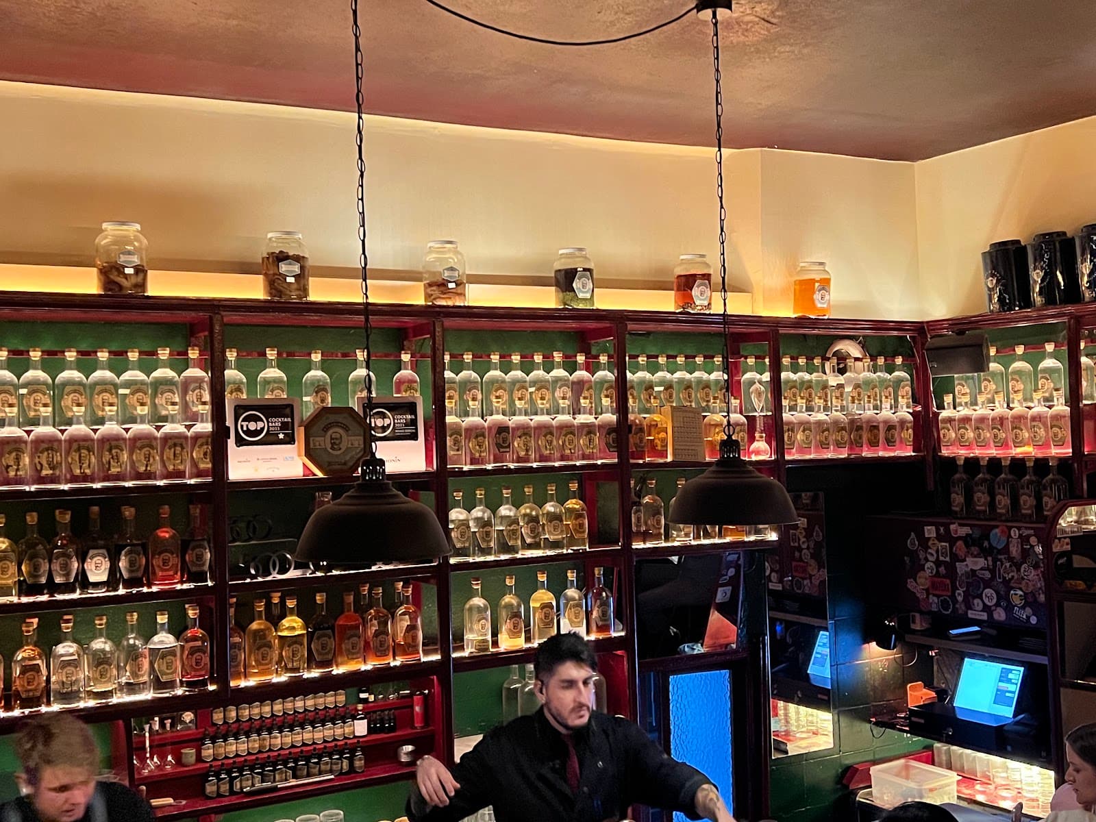 Bar counter with shelves of bottles and dim lighting in Barcelona