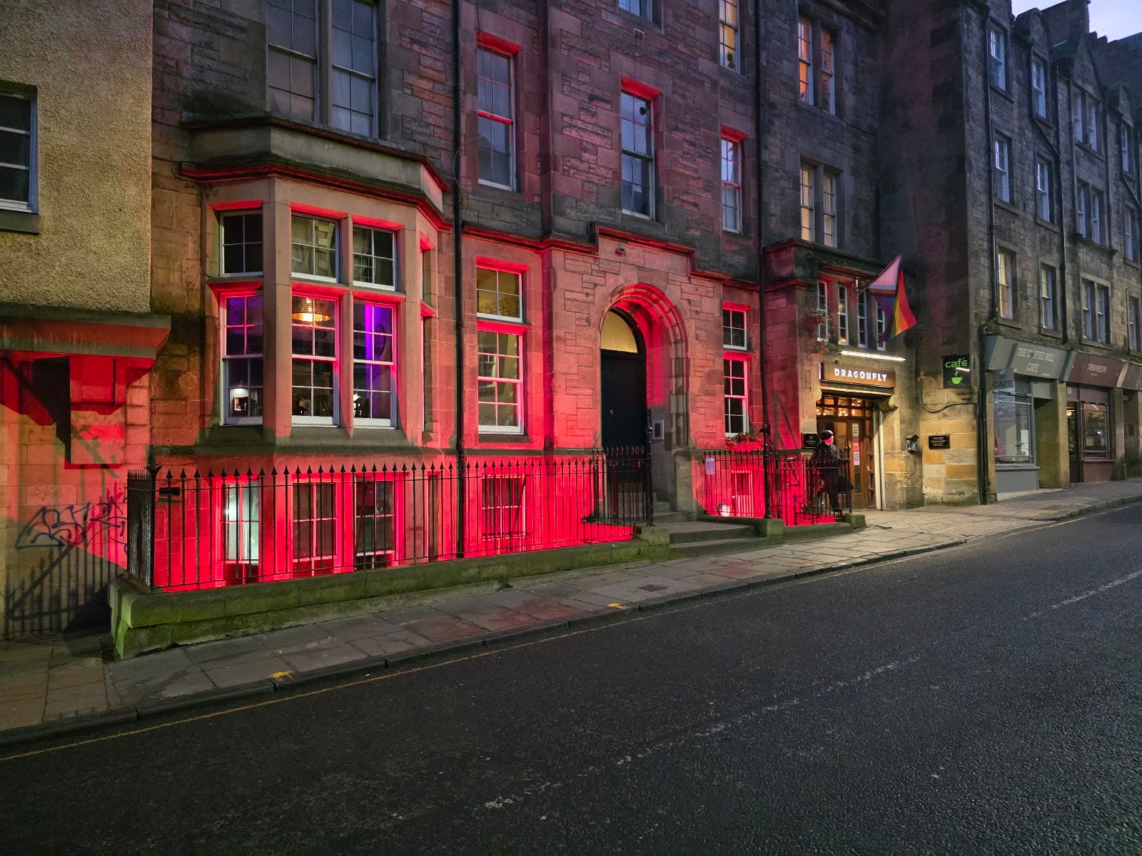 Exterior of a cocktail bar named Dragonfly with red lighting in Edinburgh
