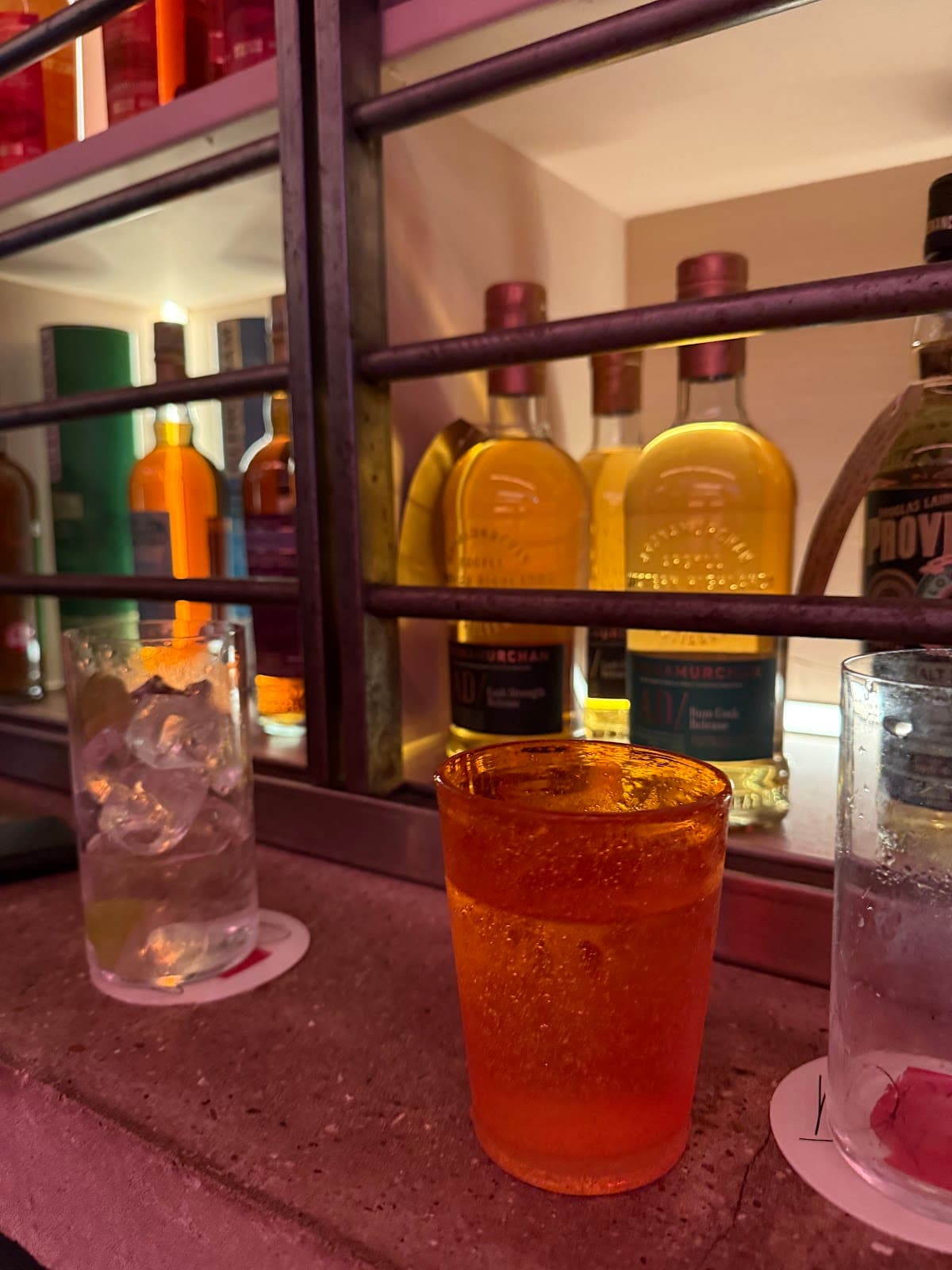 Bar counter with colorful bottles and a cocktail glass in London