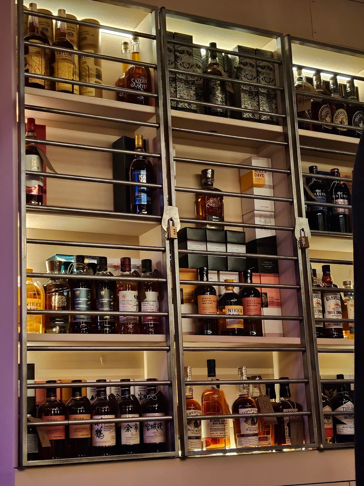 Close-up of a well-stocked bar shelf with various liquor bottles in London