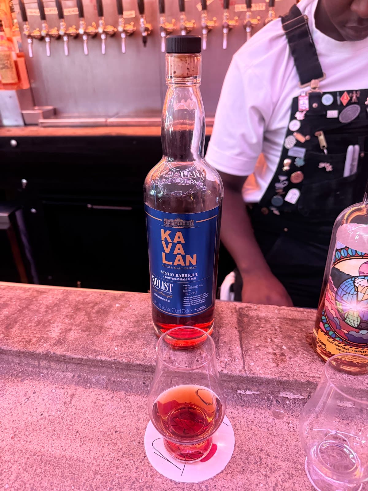 Bar counter with a glass of Kavalan whisky and bartender in the background in London