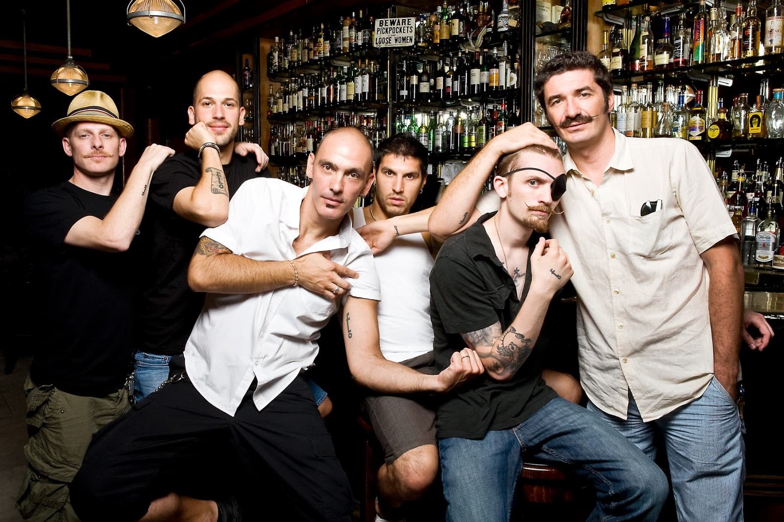 Group of bartenders posing in front of a well-stocked bar in New York