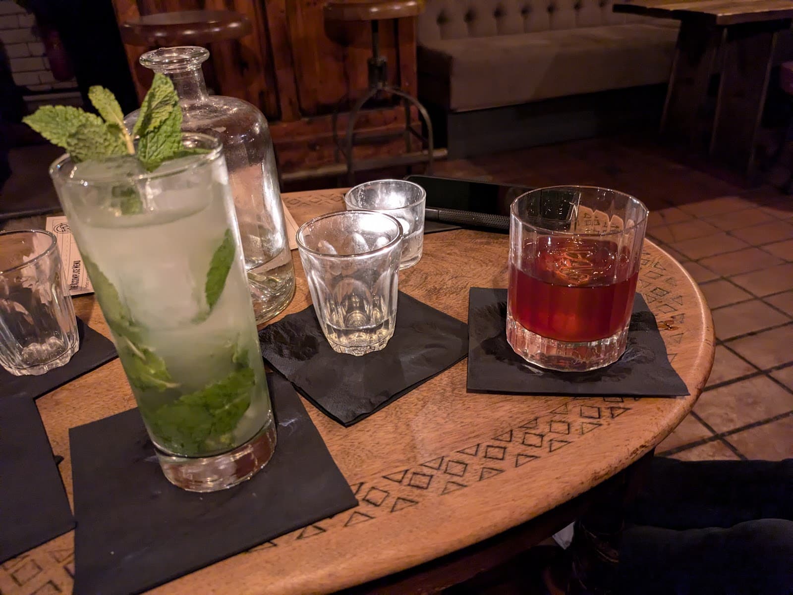 Table with cocktails in a dimly lit bar setting in London