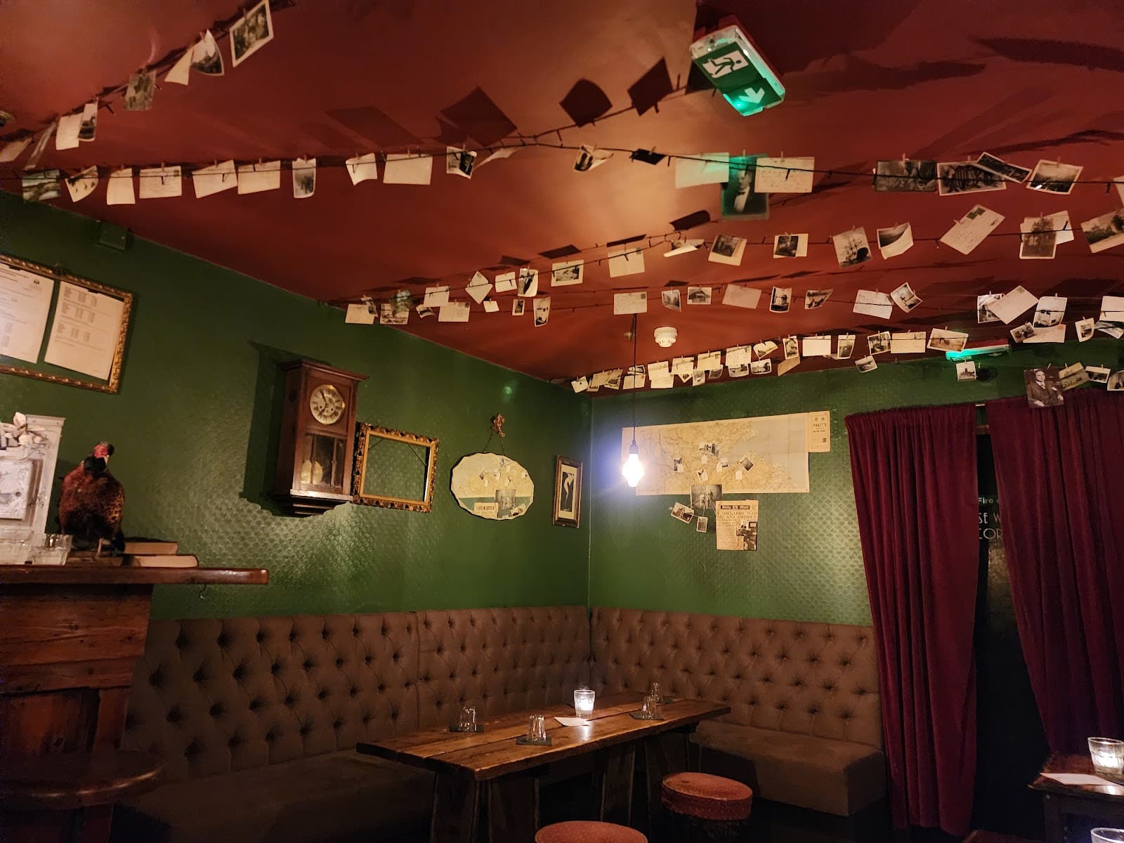 Cozy bar interior with green walls and string lights in London