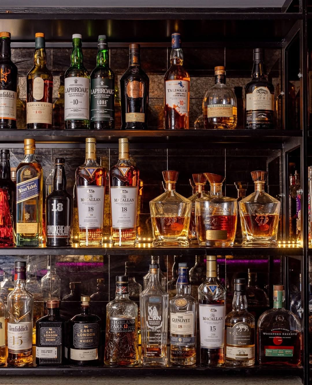 Close-up of a bar shelf displaying various whiskey bottles