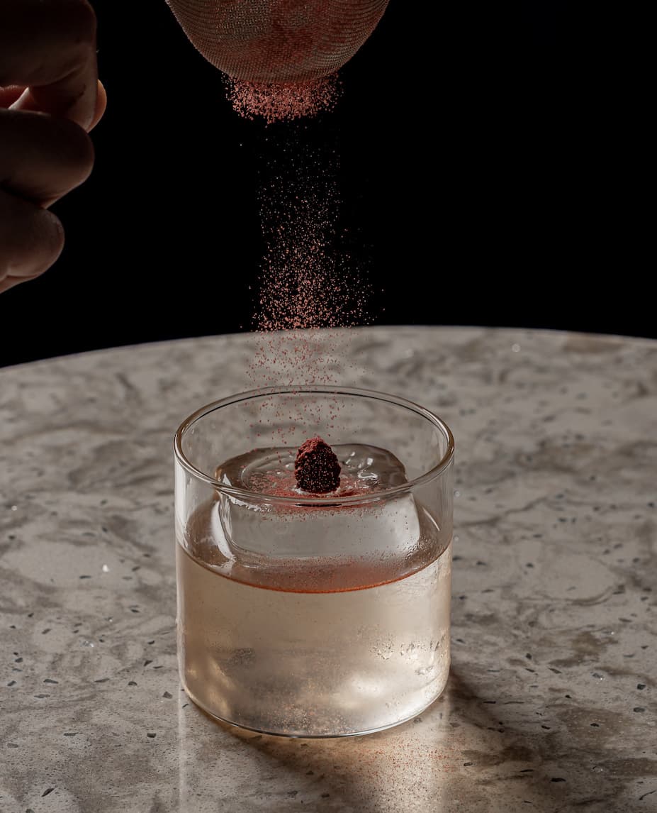 Elegantly captured cocktail with a garnish being sprinkled in London