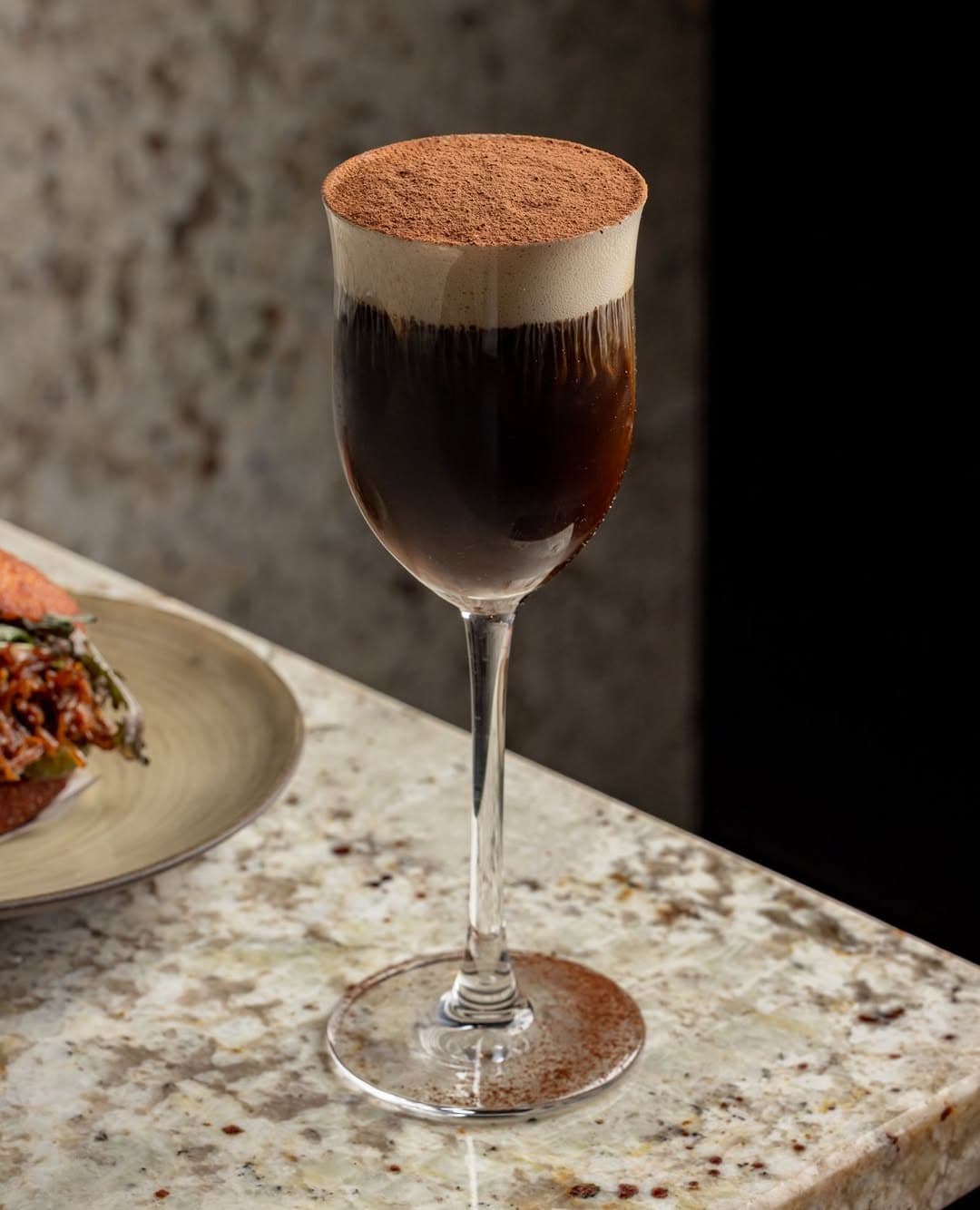 Elegant cocktail with foam and cocoa on a marble surface in London