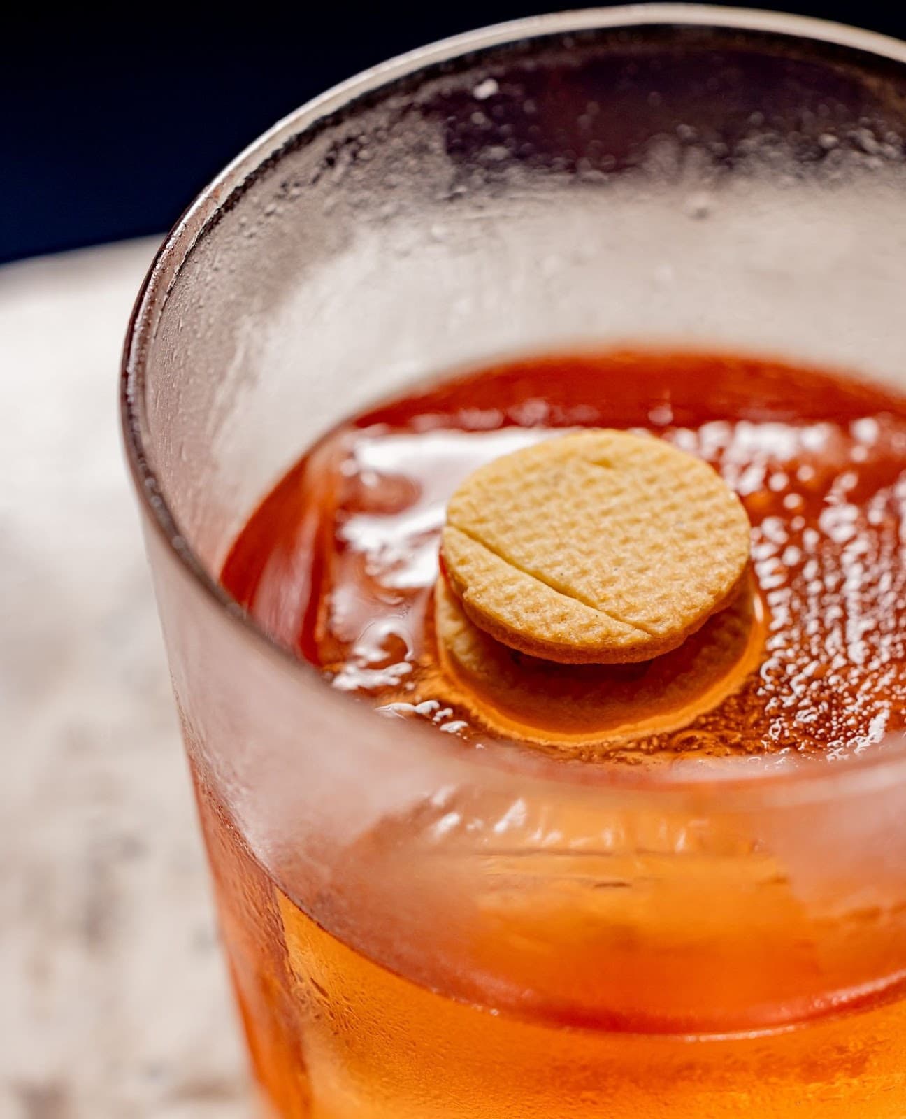 Close-up of a cocktail with an orange slice garnish in a frosted glass in London