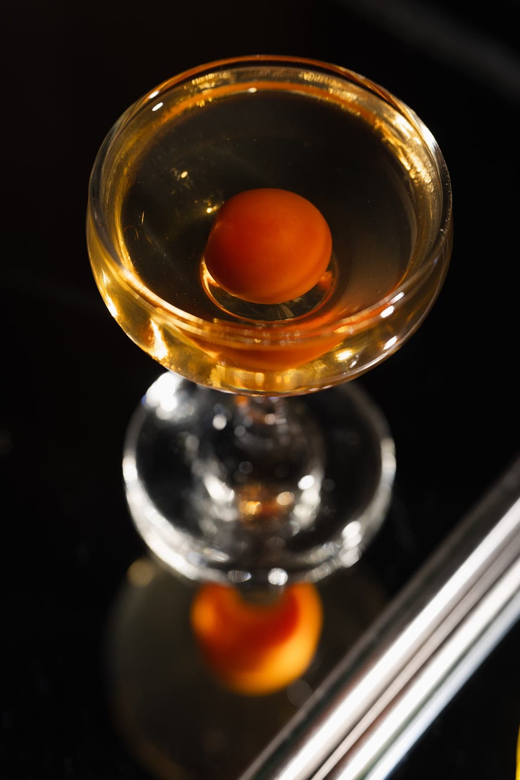 Close-up of a cocktail with an orange sphere garnish in Paris