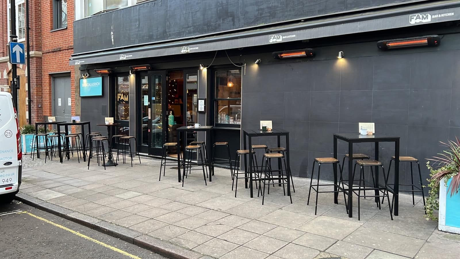 Exterior of FAM bar with outdoor seating and warm lighting in London
