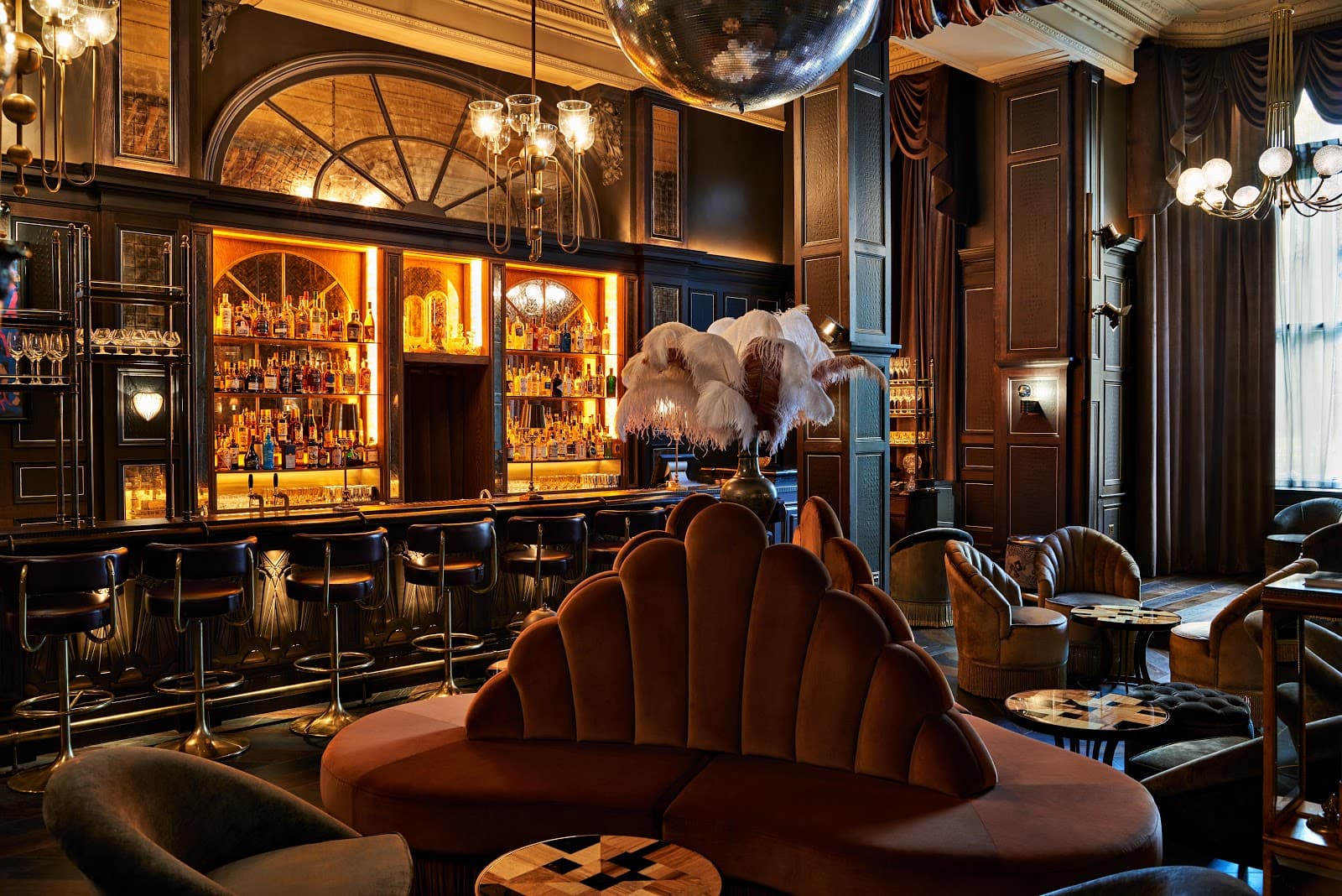 Elegant bar interior with plush seating and illuminated liquor shelves in London