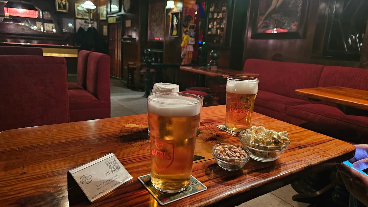 Cozy bar interior with drinks and snacks on a wooden table in Lisboa
