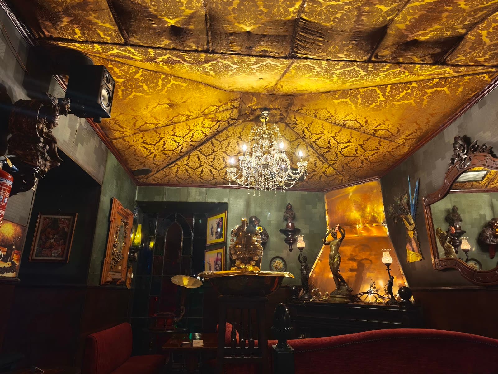 Luxurious cocktail bar interior with ornate ceiling and chandelier lighting in Lisboa