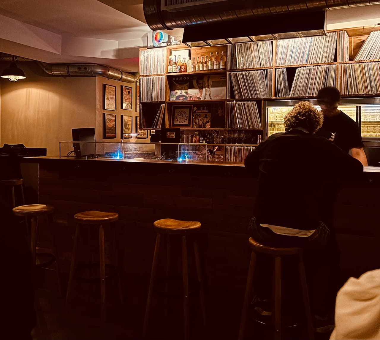 Cozy bar area with vinyl records and bar stools in Paris
