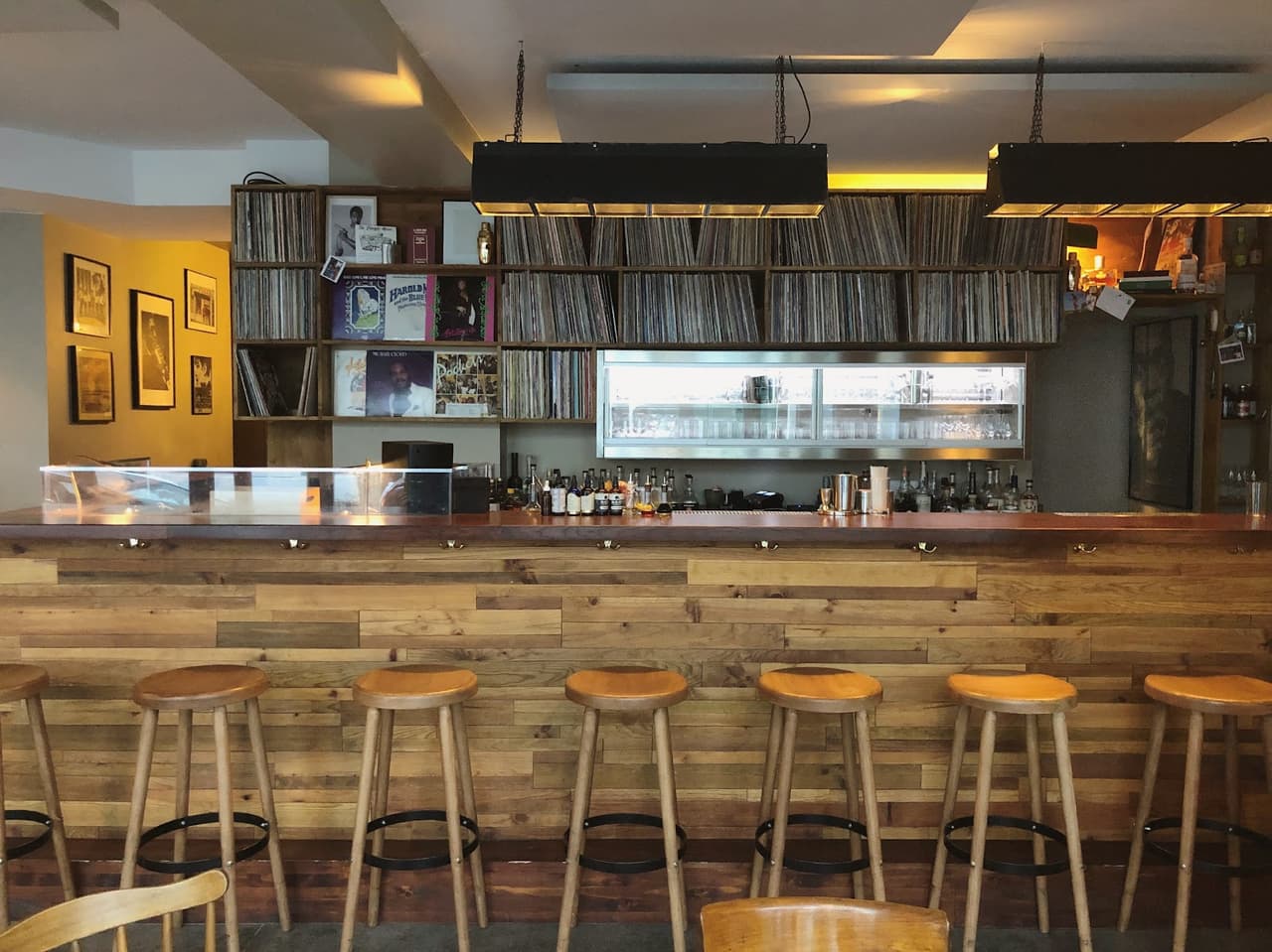 Stylish bar with wooden stools and shelves filled with vinyl records