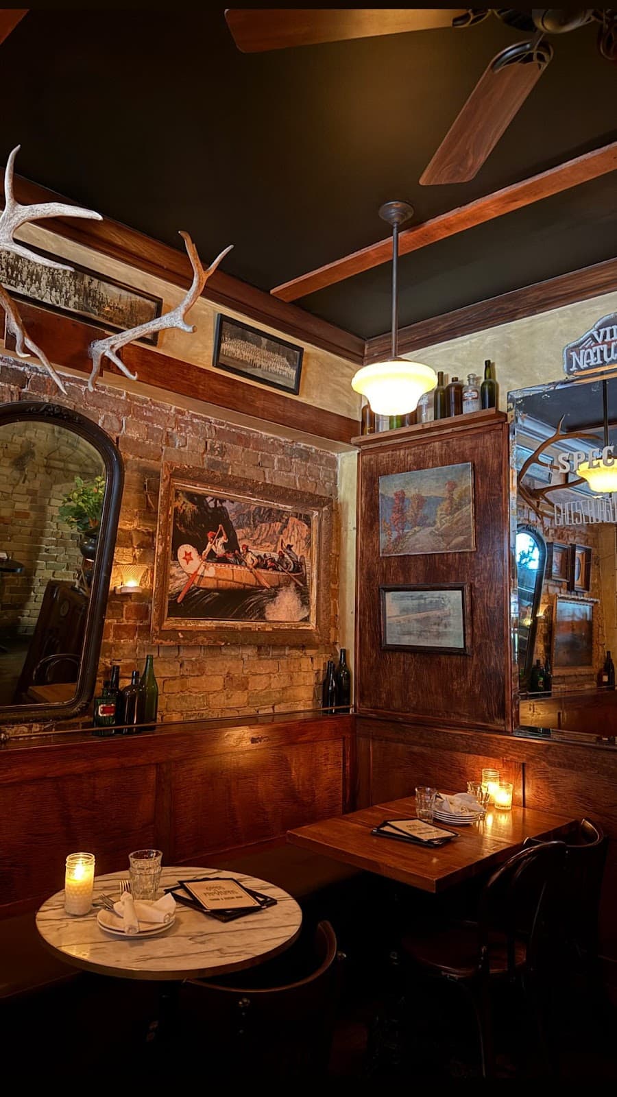 Cozy interior with exposed brick, wood paneling, and candlelit tables in Toronto