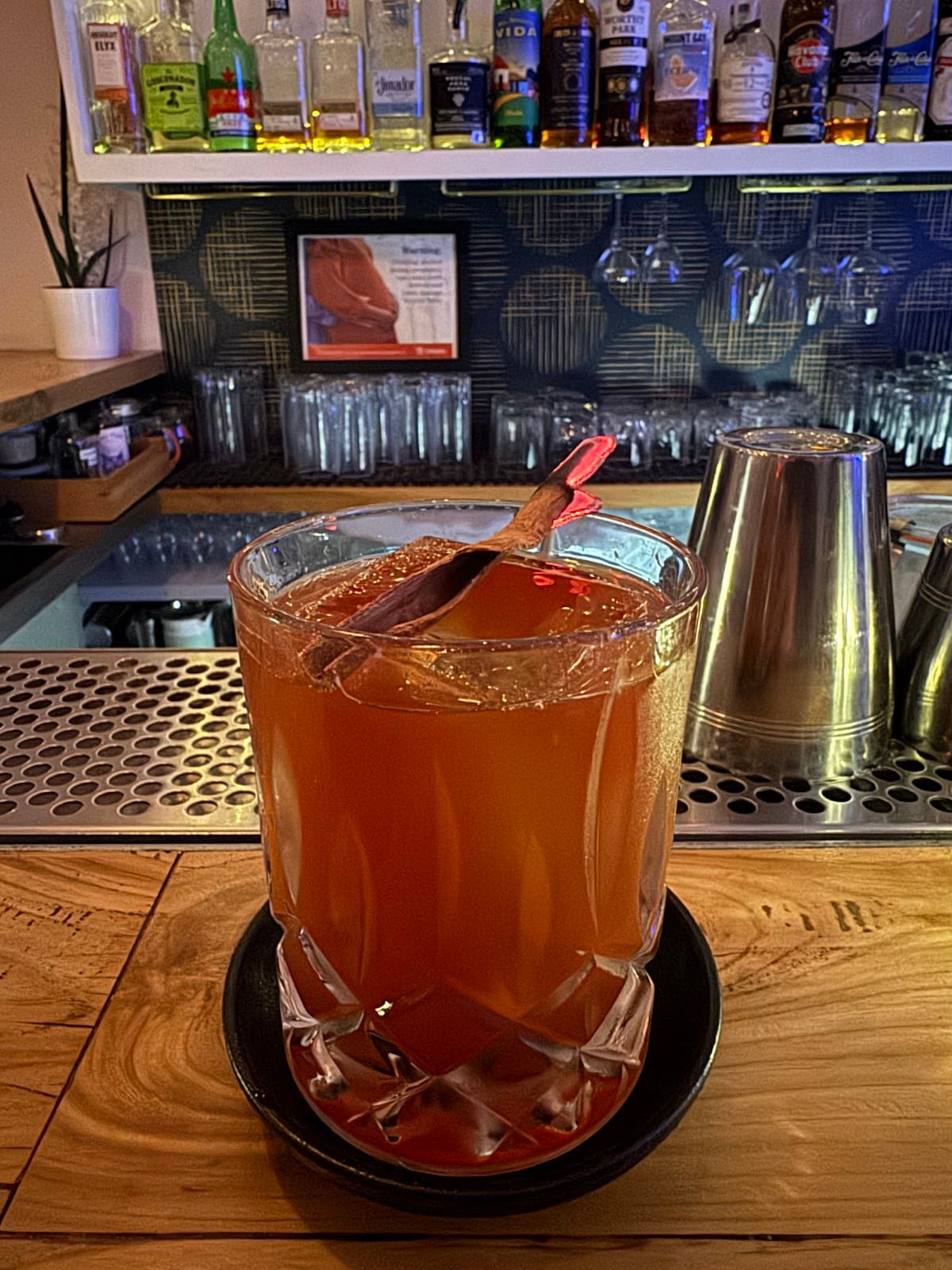 Close-up of a cocktail in a crystal glass at a bar with bottles in the background in Toronto