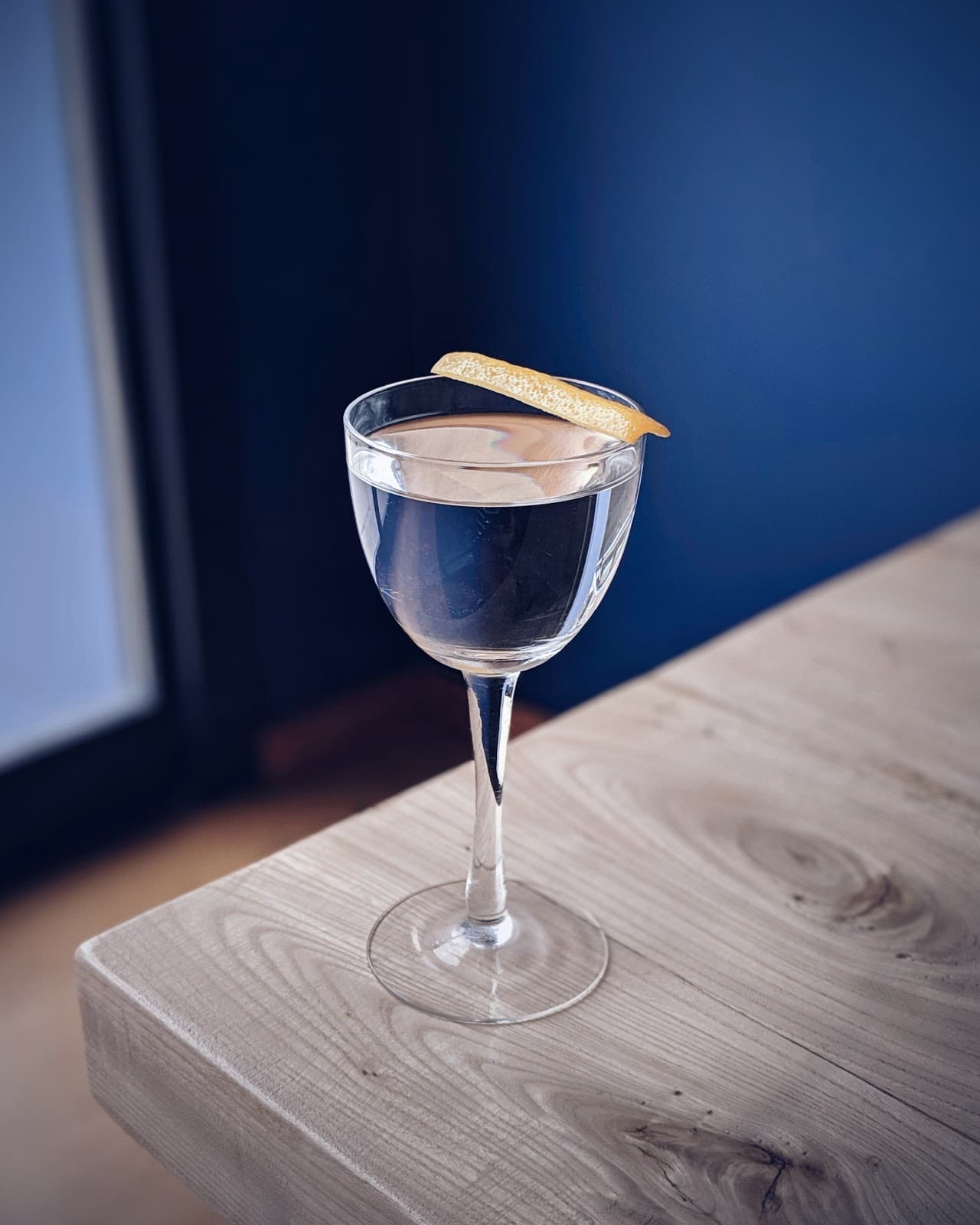 Elegant cocktail with lemon garnish on wooden table in Toronto