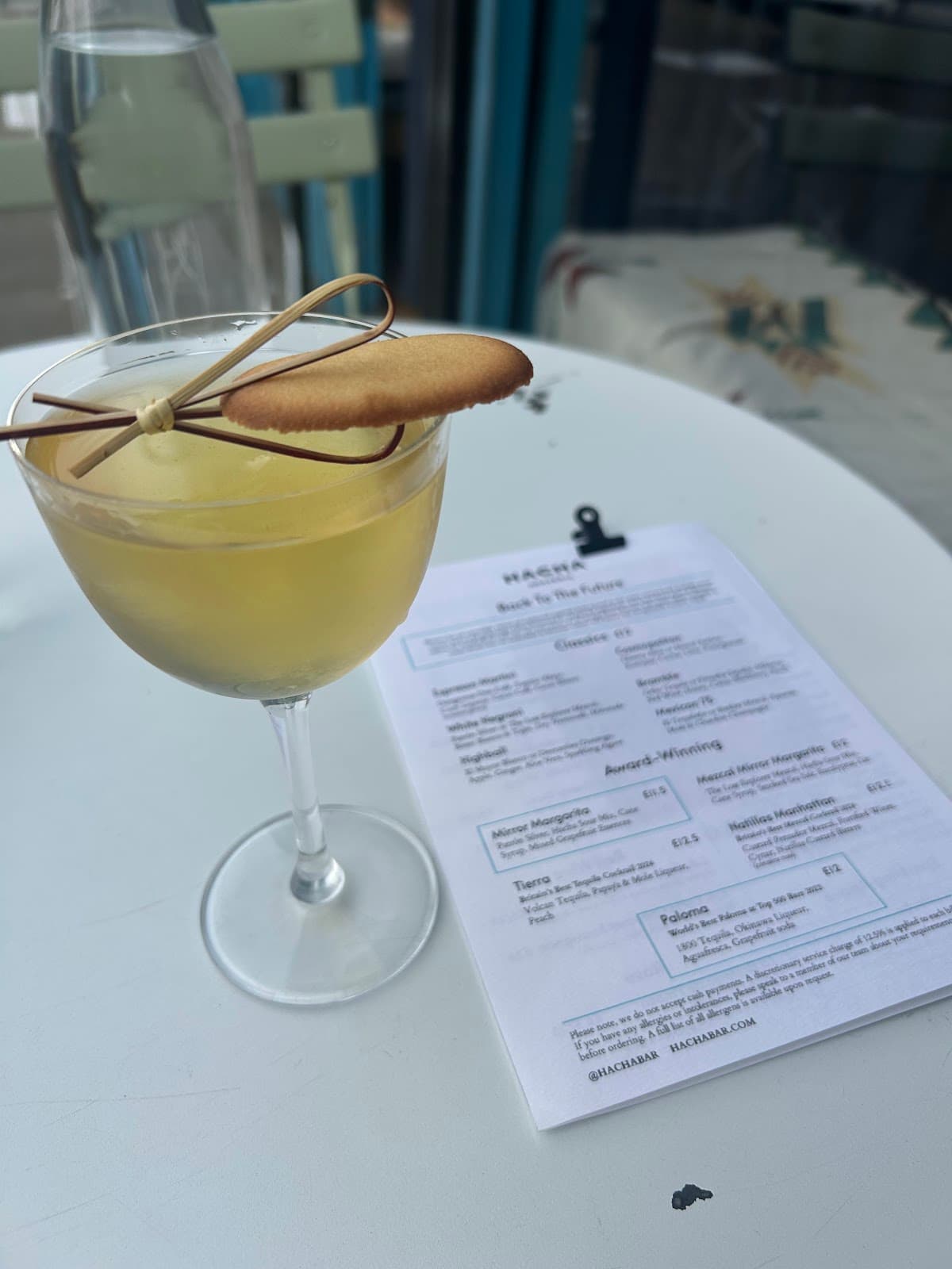 Cocktail on a white table with a drink menu in the background in London