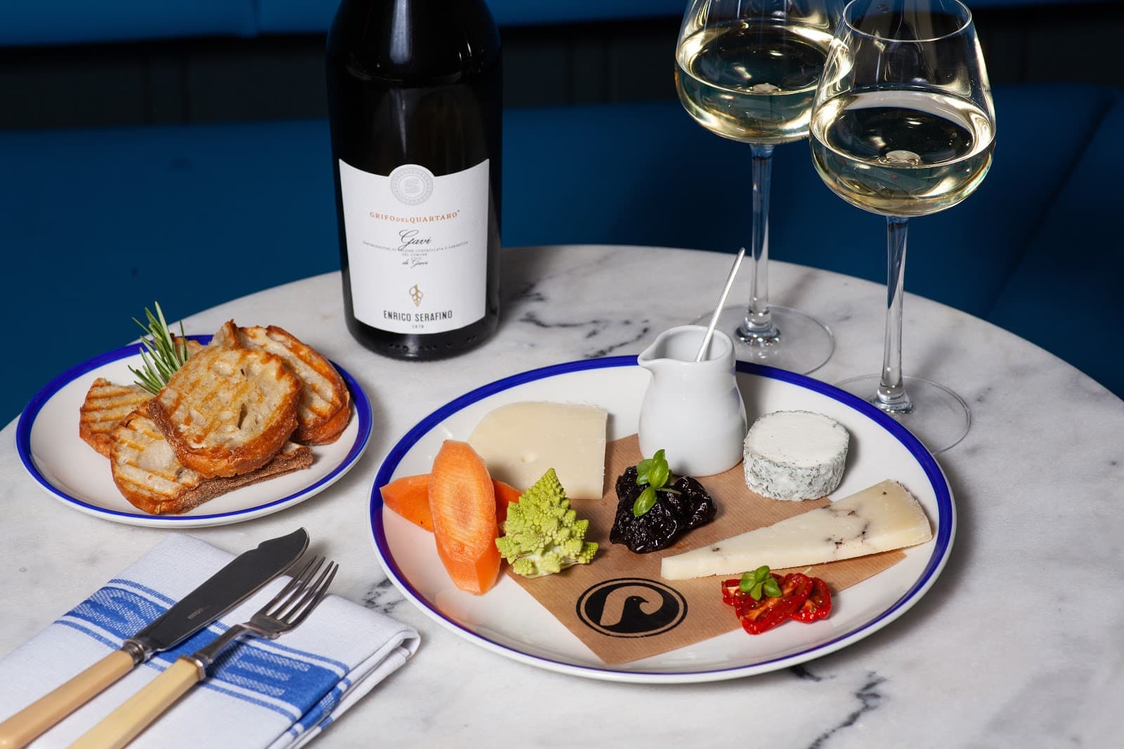 Plate of cheese and wine glasses on a marble table at a cocktail bar in Edinburgh