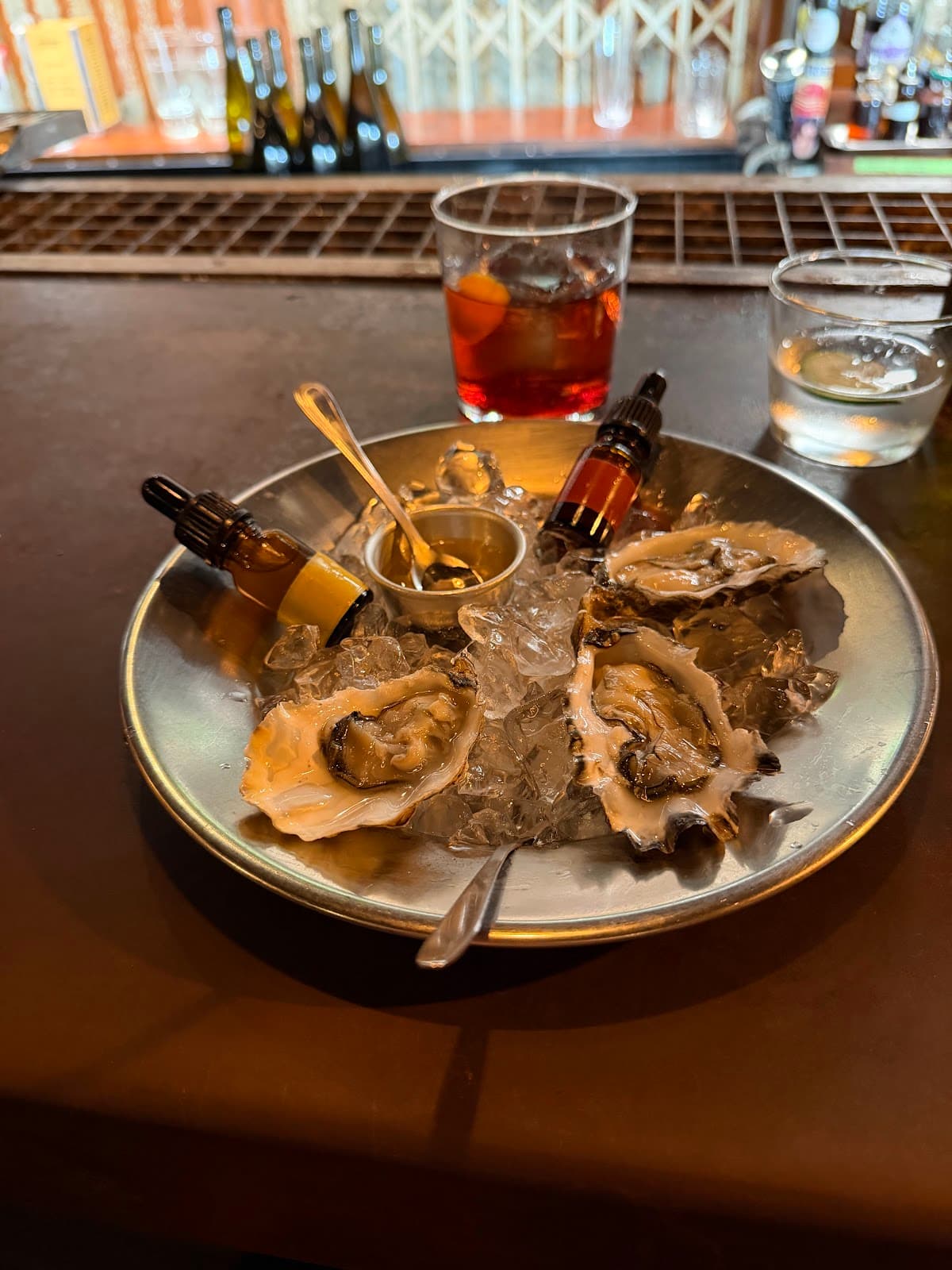 Oysters on ice with cocktails and bar in background in Lisboa