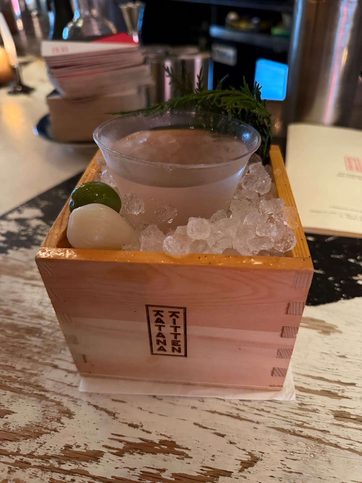 Cocktail served in a wooden box with ice at Katana Kitten in New York